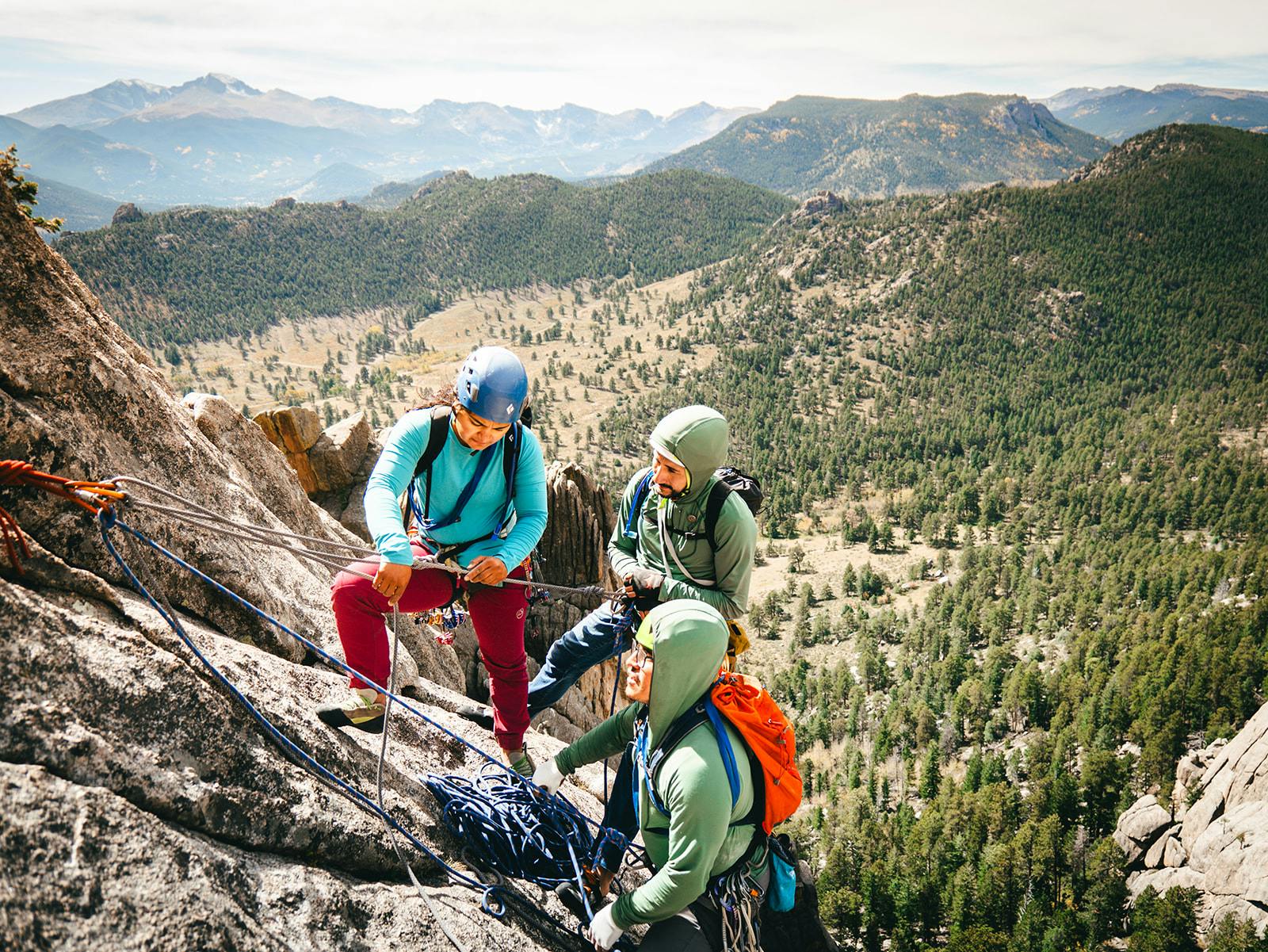 Three participants from the BIPOC Rock Guide course prepare to rappel. 