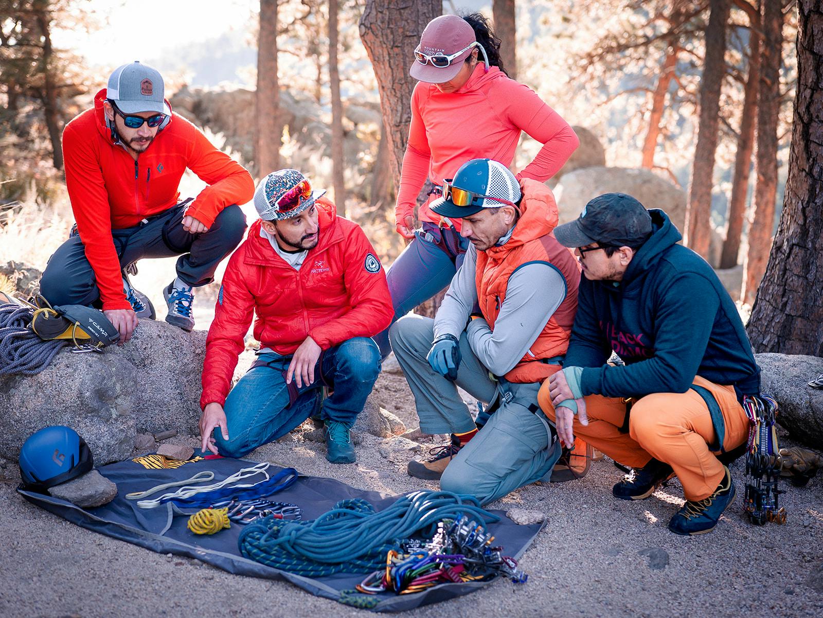 Participants of the AMGA BIPOC Rock Guide Course look at gear. 